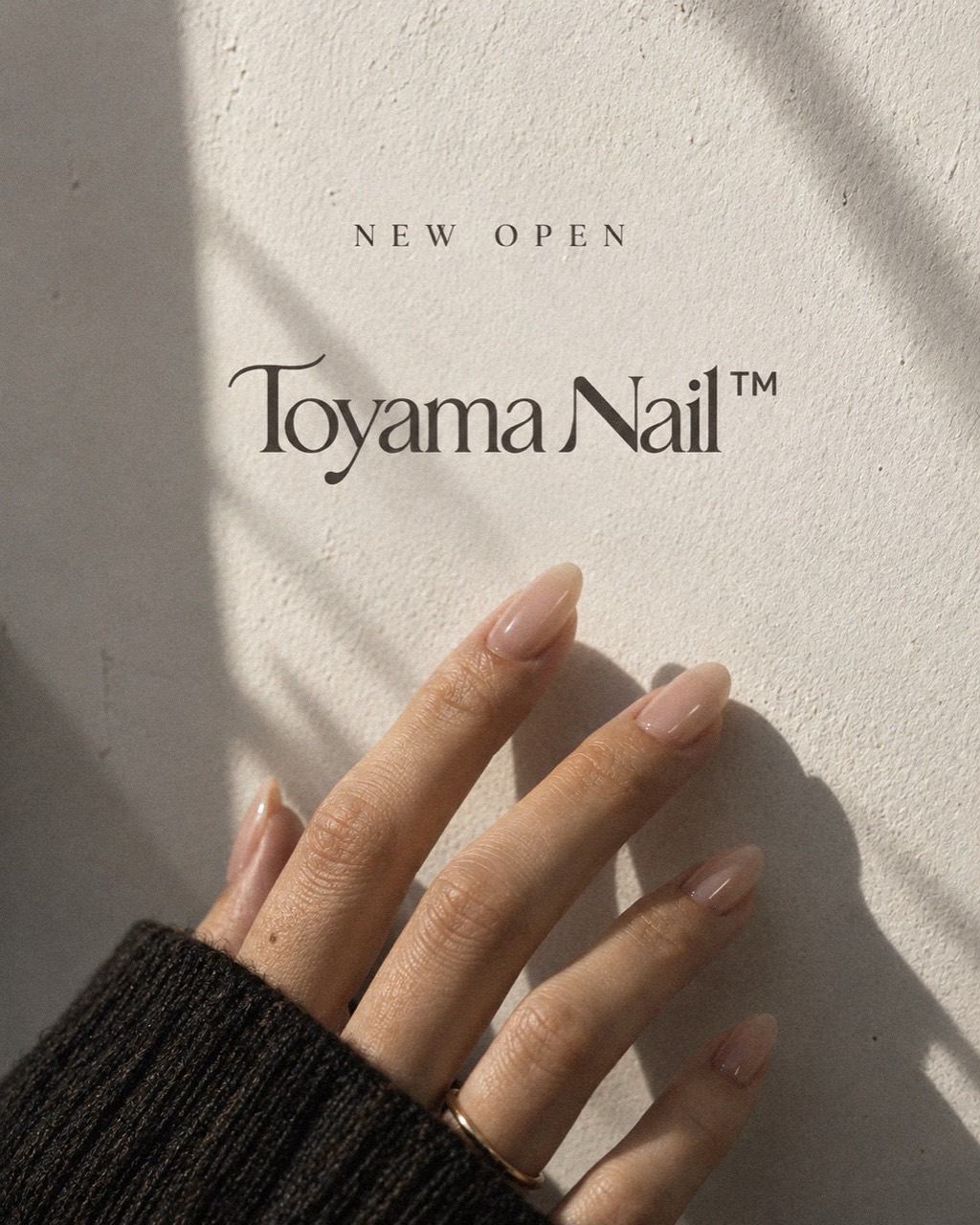 Toyama Nailの新しいロゴと、自然光に艶めくヌードピンクのネイル